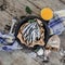 Fresh anchovies on plate with on a baking paper with a food around on the blue napkin near the fork