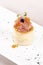 Fresh appetizer with smoked salmon and caviar,  on pastry,  decorated with eatable purple  flower and green leaf,  placed on white