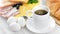 Fresh appetizing breakfast cup coffee fresh croissant muesli eggs cheese on serving table close-up