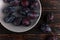 Fresh appetizing plums in a gray bowl, summer concept, copy space