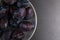 Fresh appetizing plums in a gray bowl, summer concept, copy space