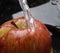 fresh apple during the cleaning process under running water