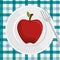 fresh apple over plate and fork with checkered tablecloth