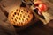 A fresh apple pie in a bakery box on a rustic wood table with plate, serving utensil and fresh Fuji apples ans warm side light
