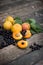 fresh apricots, black currant in a glass bowl transparent scattered on the old wooden tabletop