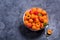 Fresh apricots in colander on dark copy space background, summer fruits