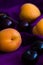 Fresh apricots (Farteli, Spain) and cherries (Sweetheart, England) on a purple silk background with copy space. Selective focus.