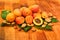 Fresh apricots, leaves and seeds on wooden surface