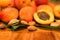 Fresh apricots, leaves and seeds on wooden surface