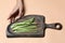 Fresh asparagus on a wooden cutting board on pink background