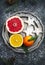 Fresh assorted citrus fruits and Christmas cookies on plate