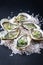 Fresh Australian Sydney rock oysters with garlic and salt on a black design board