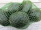 Fresh avocado fruit in nylon and plastic net bag