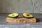 Fresh avocado halves on a wooden cutting board