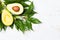 Fresh avocado palta with leaves, wooden white background