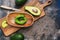 Fresh avocado sliced in a wooden bowl on a cutting board. Top view, copy space