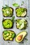 Fresh avocado toasts with different toppings. Healthy vegetarian breakfast with rye wholegrain sandwiches.