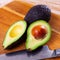 Fresh avocadoes and kitchen knife on cutting board