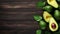 Fresh avocados with leaves on wooden table with space for text
