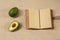 Fresh Avokado and Opened Notebook lying on a sackcloth surface