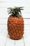 Fresh azores pineapple fruit on a white wooden backgrou