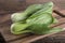 Fresh baby Bok Choy Chinese cabbage on cutting board and on table