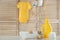 Fresh baby towel, toys, bottle of detergent and washing powder on wooden table
