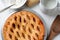 Fresh baked apple pie with a lattice crust. The pie is surrounded by baking items. Hogh angle. Horizontal format