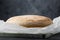 Fresh baked bread on a wooden board. Traditional round artisan rye bread loaf flour on wooden cutting board. Dark background