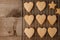 Fresh baked cinnamon-flavoured heart-shaped biscuits on vintage wooden background with copy space.