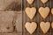 Fresh baked cinnamon-flavoured heart-shaped biscuits on vintage wooden background with copy space.