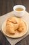 Fresh baked croissants with tea on napkin