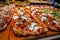 Fresh baked focaccia or pala romana pizza with vegetables and cheese in bakery in Parma, Emilia Romania, Italy close up