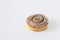 Fresh baked yellow brown bun with cream and poppy seeds close-up with shadows on a white background