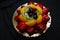 Fresh bakery made fruit tart glazed with strawberries, kiwi, peaches and blueberries on a gold tray