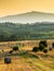 Fresh bales of hay in an Umbrian field at sunset.