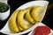 Fresh banana plate on black kitchen table, close-up. Healthy veg