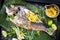 Fresh barbecue gilthead seabream with lettuce and mango chutney on a green banana leaf
