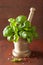 Fresh basil leaves in copper mortar