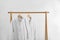 Fresh bathrobes hanging on rack near wall