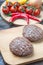 Fresh beaf burgers on cutting board with tomato, pepper and onion.