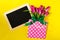 Fresh beautiful lila tulips in gift package on bright yellow background with chalkboard. Spring concept. Horizontal, top view wit