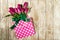 Fresh beautiful lila tulips in gift package on wooden background