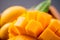 Fresh and beautiful mango fruit set in a wooden box with sliced diced mango chunks on a dark wooden background, copy space