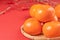 Fresh beautiful sliced sweet persimmon kaki isolated on red table background and bamboo sieve, Chinese lunar new year design