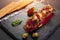 Fresh beef tartar with salt and herbs and Crispbread, studio shot. Meat tartar on black shale. On white background