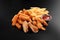 Fresh beer snacks chicken wings french fries cheese sticks assortment on black