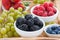 Fresh berries and green grapes on a wooden tray