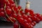 Fresh berries of red currants in a metal bucket on a gray table.