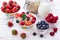 Fresh berries strawberry, raspberries and natural flakes for breakfast, Woman pouring milk into bowl with muesli top